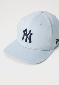 Niebieska czapka baseballowa z mieszanki bawełnianej, z naszytym granatowym logo NY z przodu oraz usztywnionym daszkiem.
