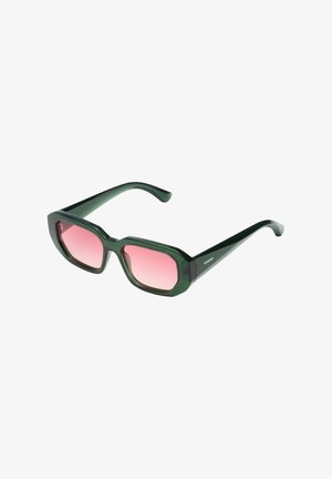 Lunettes de soleil à monture géométrique verte avec des verres dégradés roses et des branches noires, inclinées sur un fond blanc.