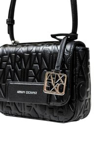 Borsa a tracolla in pelle nera con un motivo a logo in rilievo, hardware dorato e un'etichetta staccabile con accenti geometrici. Dotata di una tracolla corta.
