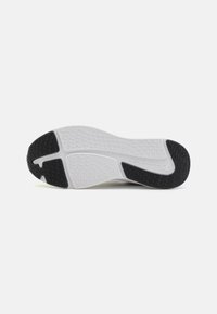 Hvit sneakersåle med teksturert overflate, svarte gummidetaljer og intrikat mønster for bedre grep og trekkraft.