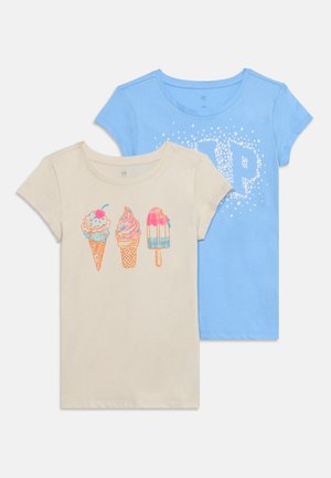 Deux t-shirts enfants à manches courtes, un beige avec imprimé cônes de glace et esquimaux, un bleu avec motif d'étoiles blanches formant la lettre P.