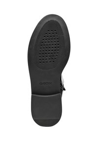 Zwarte rubberen zool met horizontale groeven en een ingebosseld logo. De vorm is ovaal met een platte hak en een afgeronde neus, wat duidt op een bedoelde gebruik als schoeisel.