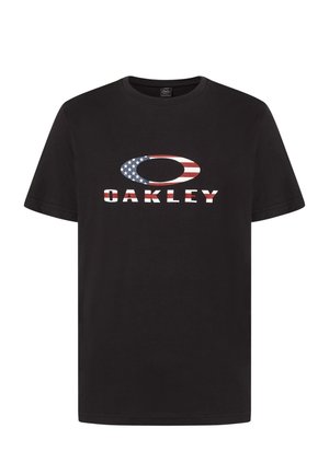Maglietta nera in cotone con un grande logo a forma ovale in rosso, bianco e blu, e la parola "OAKLEY" in lettere grassetto sotto.