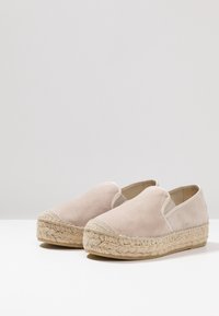 Beżowe zamszowe espadryle na wsuwane z plecioną podeszwą z liny jutowej i gładkim tekstylnym akcentem na czubku. Podeszwa płaska, kształt zaokrąglony.
