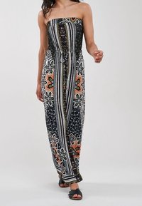 Tuta senza spalline nera con motivi floreali colorati, strisce verticali e vita stretta. Tessuto leggero con una vestibilità comoda.
