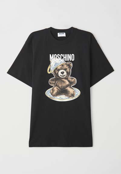 T-shirt en coton noir avec un graphique de ours portant un chapeau bleu et blanc, avec le texte "Moschino" au-dessus du design. Manches courtes, coupe décontractée.