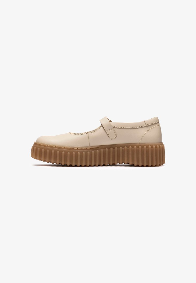 Chaussure Mary Jane beige avec semelle plateforme épaisse marron rainurée et une seule bride sur le dessus, vue de profil sur fond blanc.