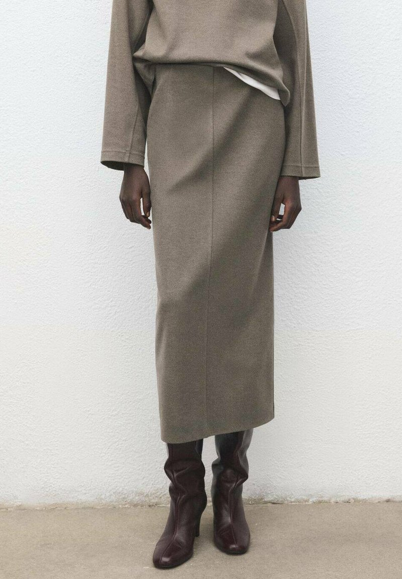 Dzianinowa, oliwkowozielona spódnica midi o dopasowanym kroju. Połączona z bordowymi kozakiem za kolano o luźnym fasonie.