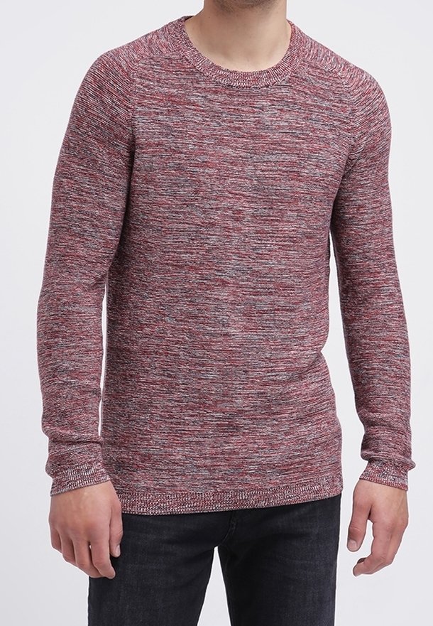 Rood en grijs gemêleerd gebreid sweater met een ronde hals en lange mouwen, voorzien van geribde manchetten en zoom, gecombineerd met donkere jeans.