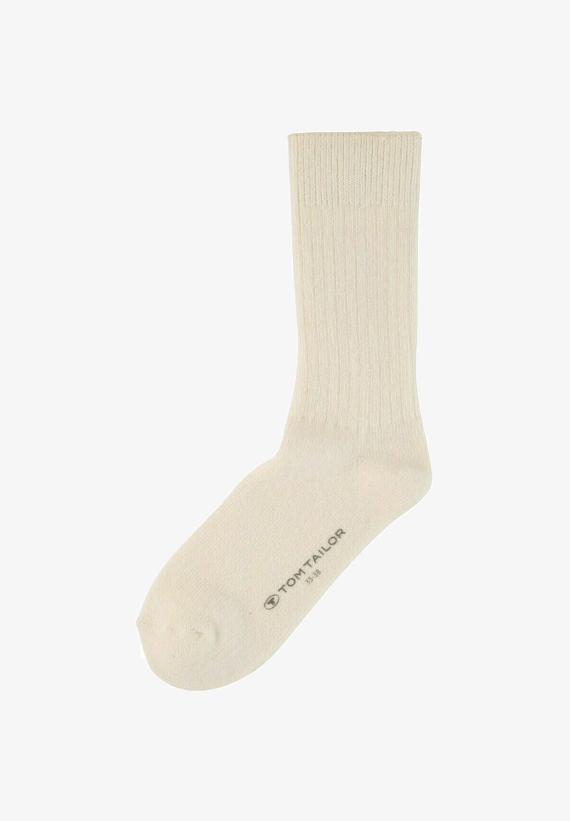 Chaussette beige côtelée en tissu doux avec une couleur unie, dotée d'un renfort aux orteils et au talon. Logo de la marque imprimé sur la semelle.
