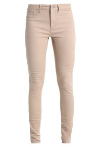 Jeans skinny beige realizzati in tessuto misto cotone, con vita bassa, design a cinque tasche e una superficie leggermente strutturata.