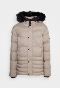 Beżowa kurtka puchowa z odczepianym czarnym kapturem z futra syntetycznego. Posiada zatrzaski, pionowe przeszycia oraz logo na rękawie.