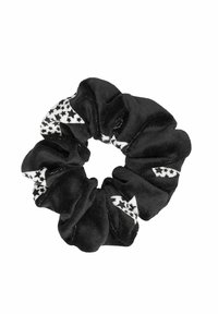 Svart scrunchie med en blank yta som har vita stjärnmönster på två sektioner, vilket ger kontrast och visuell intress.