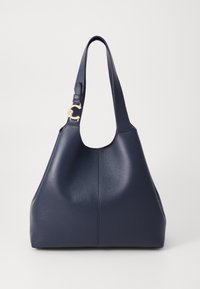 Navy leather hobo bag with a textured surface, a wide shoulder strap, and a gold logo hardware detail on the strap. Minimalist design.
