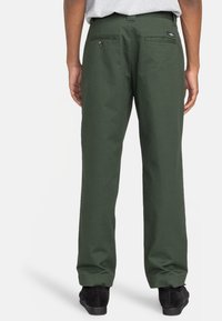 Pantalons en coton vert avec une coupe droite, dotés de deux poches arrière et d'une boucle de ceinture à la taille. Le matériau semble robuste avec une texture lisse.