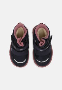 Stivaletti per bambini di colore blu navy con due cinghie regolabili, foderati in pile rosa e suole in gomma rossa. Materiale strutturato con cuciture a contrasto.