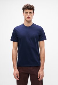 T-shirt in cotone blu navy con collo rotondo, maniche corte e un piccolo dettaglio logo sul petto. Design semplice e leggero.