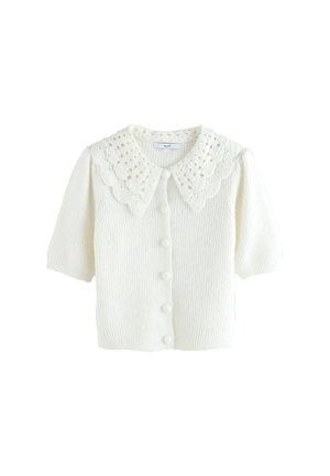 Gilet en tricot blanc avec des manches courtes, texture côtelée et un grand col en dentelle festonnée. Six boutons sur le devant.