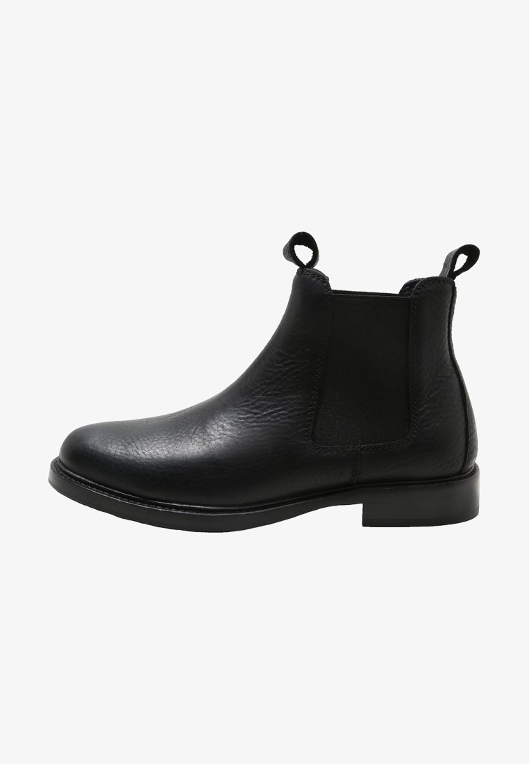 Botte Chelsea en cuir noir avec panneau latéral élastique, languettes à l'avant et à l'arrière, talon bas et bout arrondi.