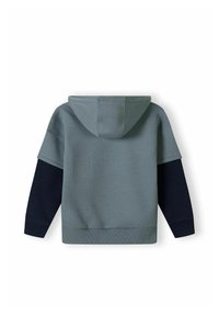 Sudadera con capucha que presenta un cuerpo verde azulado y mangas azul marino, hecha de una tela suave con puños y dobladillo acanalados, mostrando un diseño simple y moderno.