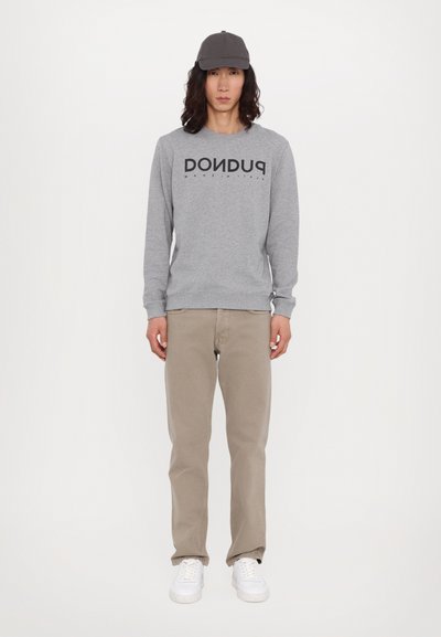 Szary sweatshirt z czarnym napisem "DONDU", beżowe spodnie i białe sneakersy. Dodatki to szary czapka. Prosty, codzienny strój.