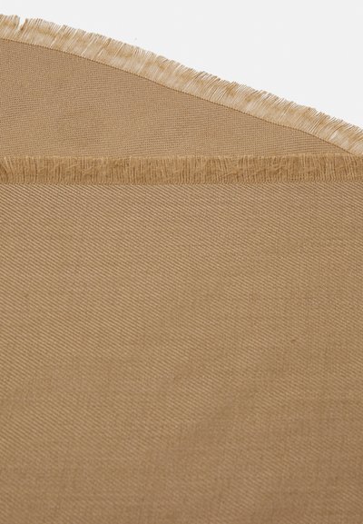 Beige stoff med en teksturert overflate og frynsekant, som viser et vevd mønster og en myk, matt finish.