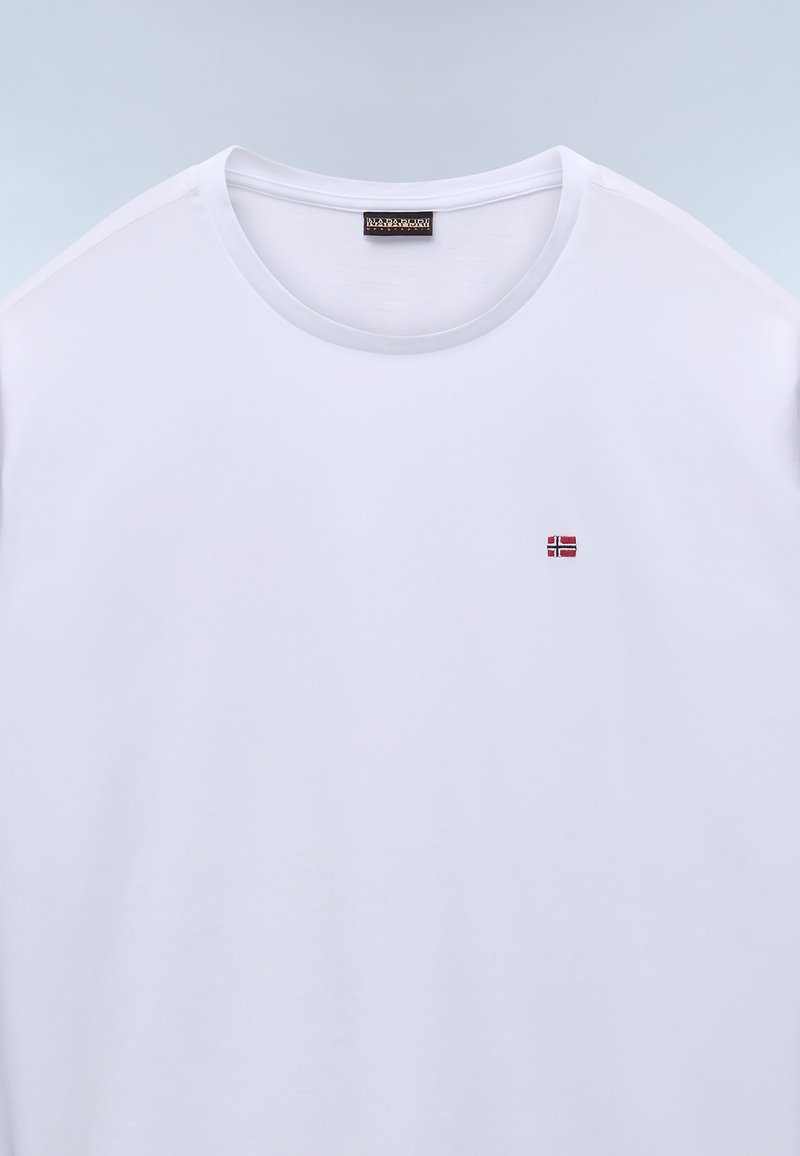 T-shirt bianco in cotone con collo rotondo e maniche corte. Presenta una piccola bandiera norvegese ricamata sul lato sinistro del petto. Texture liscia.