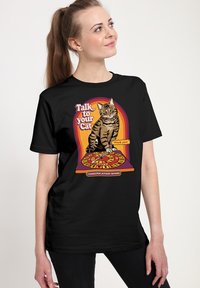 Maglietta nera con la grafica di un gatto tigrato e la scritta "Parla con il tuo gatto", con un design colorato di una tavola di comunicazione.