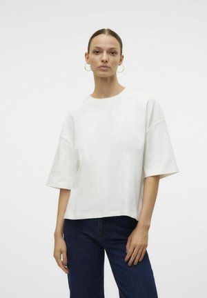T-shirt bianco a maniche corte con vestibilità rilassata, scollatura rotonda, texture liscia e cuciture delle spalle abbassate. Abbinato a jeans scuri.