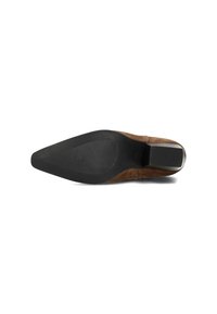 Zapato de tacón de ante marrón con punta afilada y suela de goma negra texturizada. Presenta un tacón cuadrado con un acabado suave.