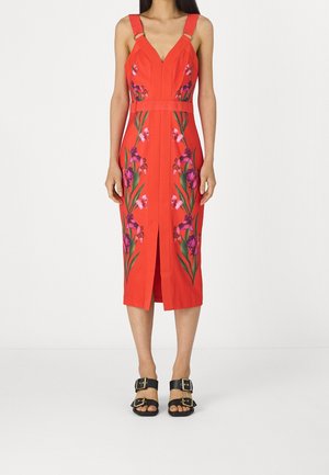 Punainen kukkakuvioinen mekko, jossa on istuva siluetti, V-pääntie ja leveät olkaimet metallikoristeilla. Hameen edessä halkio.