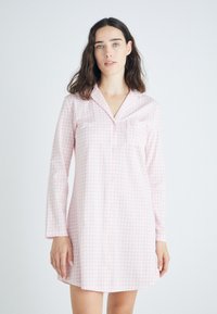 Robe de nuit en coton rose clair avec un motif vichy, des manches longues, un devant boutonné et une poche poitrine.
