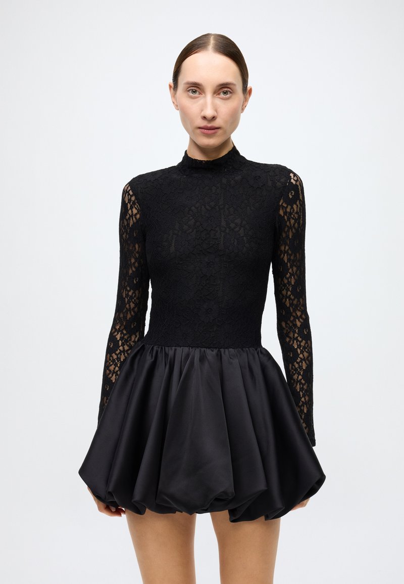 Black dress featuring a lace top with long sleeves and a mock neckline, transitioning to a satin balloon skirt with a smooth texture.