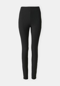 Leggings noirs taille haute avec une texture côtelée. Design ajusté, jambes fuselées, avec des accents zippés au niveau des ourlets de cheville. Tissu lisse.