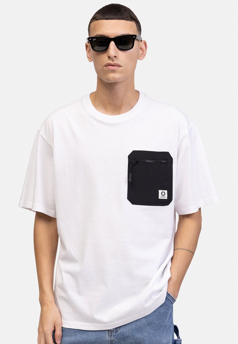 White cotton t-shirt with short sleeves, featuring a black zippered pocket on the left chest and a small brand label on the pocket.