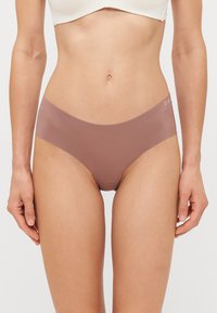 Sous-vêtements bruns sans coutures avec une texture lisse et un design taille basse. Présente un logo discret sur la ceinture, avec une coupe à couverture minimale.