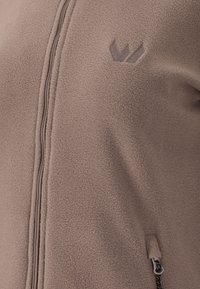 Giacca in fleece di un color marrone chiaro. Caratterizzata da una zip frontale, tasca laterale con zip a contrasto e un piccolo logo ricamato sul petto.