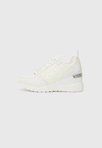 Sneaker bianco con logo DKNY in tessuto testurizzato, dotato di suola con zeppa e accento metallico lucido sul tallone. Chiusura con lacci e linguetta per il tallone.