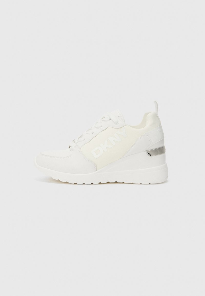 Sneaker bianco con logo DKNY in tessuto testurizzato, dotato di suola con zeppa e accento metallico lucido sul tallone. Chiusura con lacci e linguetta per il tallone.