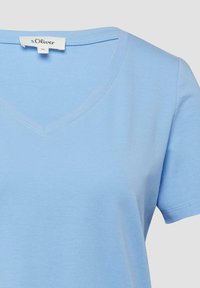 Hellblaues T-Shirt mit kurzen Ärmeln und V-Ausschnitt, mit s.Oliver Markenetikett und Grösse 36 Schildchen innen am Kragen.