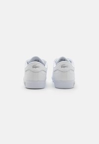 Sneaker bianche in pelle con una finitura liscia, caratterizzate da un logo grigio testurizzato sul tallone, imbottitura morbida e suola in gomma per la presa.