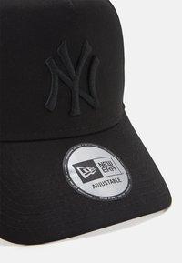 Schwarze Baseballmütze aus strukturiertem Stoff. Mit gesticktem NY-Logo und verstellbarem Riemen. Enthält ein rundes New Era-Tag auf dem Schirm.