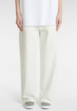 Light beige wide-leg pants with two side pockets, featuring a textured fabric. Worn with checkered slip-on shoes.