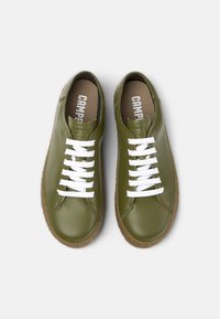 Sneaker in pelle verde con lacci bianchi, punta tonda e suola in gomma beige. Presenta il logo sulla linguetta e dettagli di cucitura laterale.