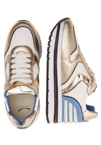 Sneaker bianche e dorate con finitura lucida, design con lacci, accenti blu a contrasto e suola chunky bianca e nera.