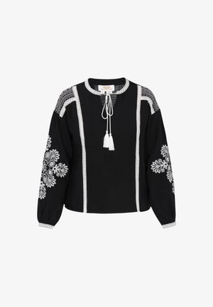 Fekete blúz fehér hímzett virágmintákkal, csipke részletekkel és megkötős nyakkal. Hosszú, ráncolt ujjaival és laza fazonával rendelkezik.