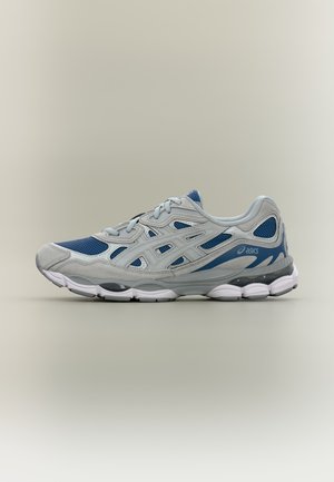 Szaro-niebieski but do biegania ASICS z białą i czarną amortyzowaną podeszwą wyświetlony na neutralnym tle.