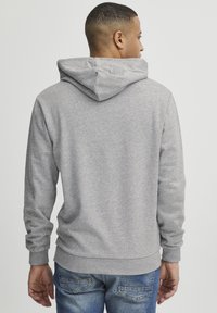 Grey hoodie with a drawstring hood, ribbed cuffs, and hem. Made from soft material, featuring a smooth texture and casual fit.