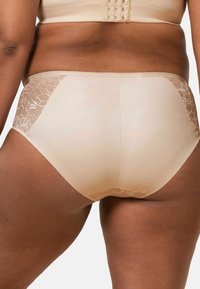 Beżowa bielizna z koronkowymi akcentami po bokach, gładka tkanina i pełne pokrycie. Elastyczny pas zapewnia dopasowanie.