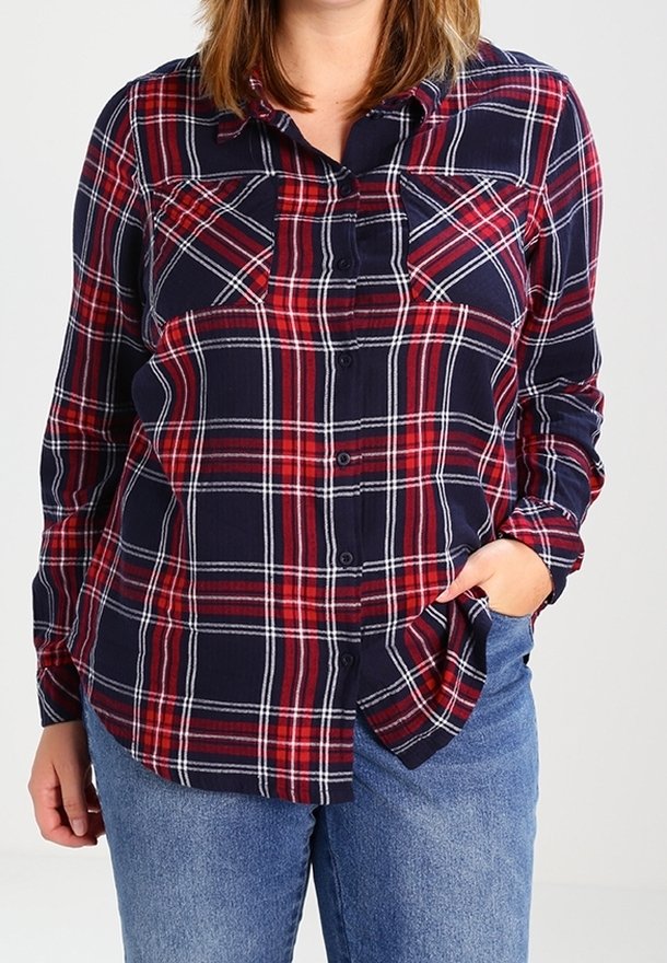 Marineblauw en rood geruit flanellen overhemd met een knoopsluiting aan de voorkant, twee borstzakken en lange mouwen. Zachtere textuur en een ontspannen pasvorm.